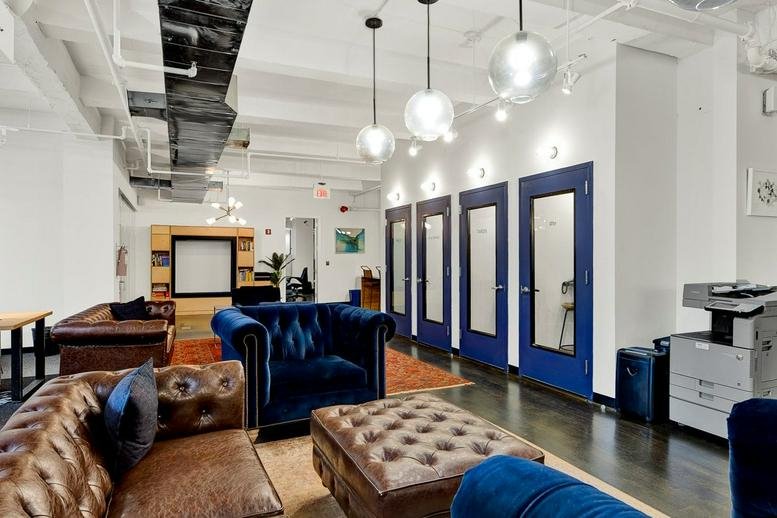 Spacious communal lounge at 27 Baker Street, Marylebone featuring blue velvet and leather seating.