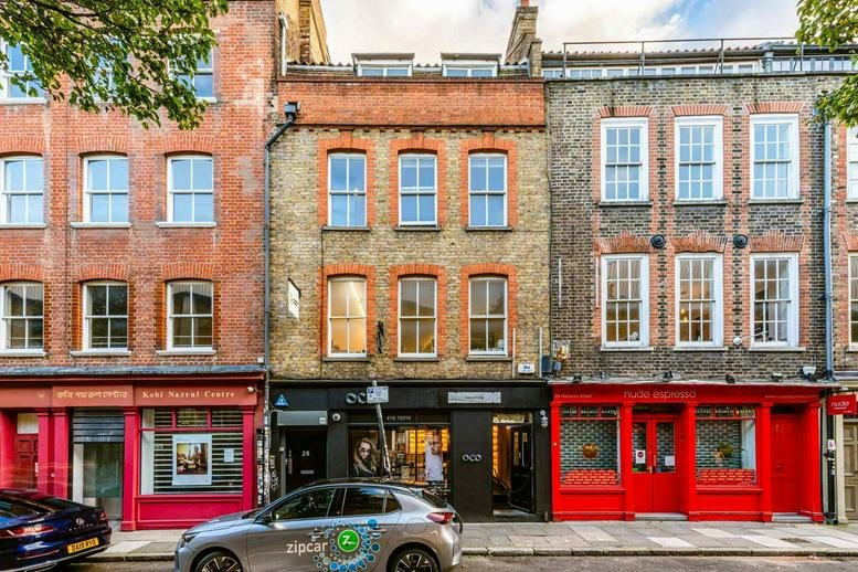 Exterior view of the historic brick building at 28, Hanbury Street featuring red and grey facades.