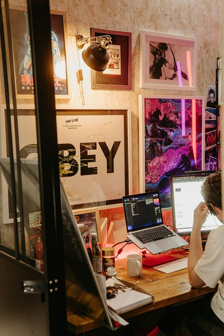 Creative workstation at 282 Leigh Road featuring vibrant posters and a dual-monitor setup.