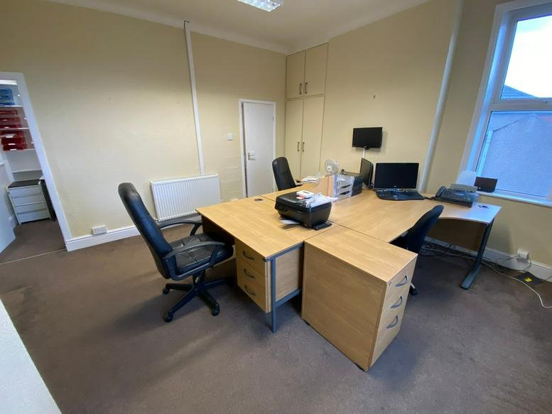 Spacious three-person office suite at 29a Larchfield Street with wooden desks and black ergonomic chairs.