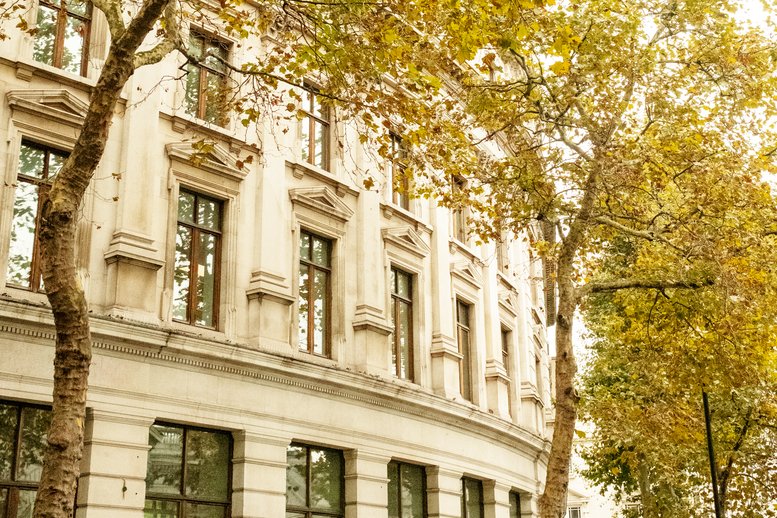 Exterior view of the ornate stone facade and autumn trees at 2a Charing Cross Road.