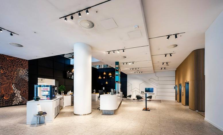 Spacious modern lobby at 2c, Trompenburgstraat, Amsterdam-Zuid with a white reception desk and feature lighting.