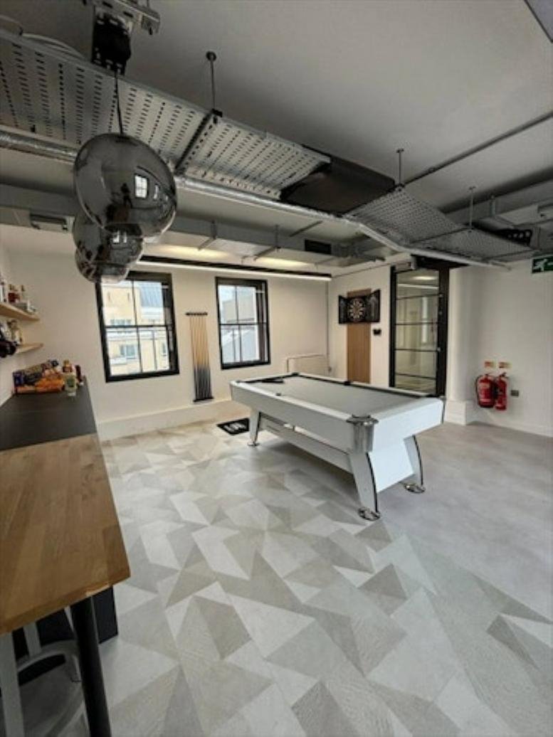 Spacious breakout room at 3 Moorgate Place featuring a white pool table and geometric patterned flooring.