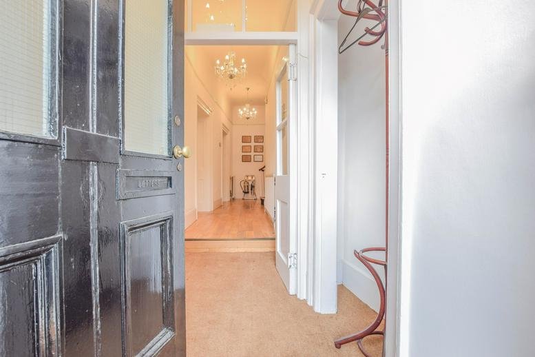 Bright hallway at 3 Port Hill, Hertford, Hertfordshire viewed from an open dark wood entrance door.
