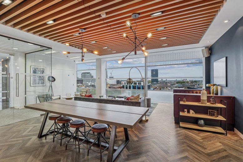 Spacious communal lounge at 30 Crown Place with a large wooden table and city skyline views.