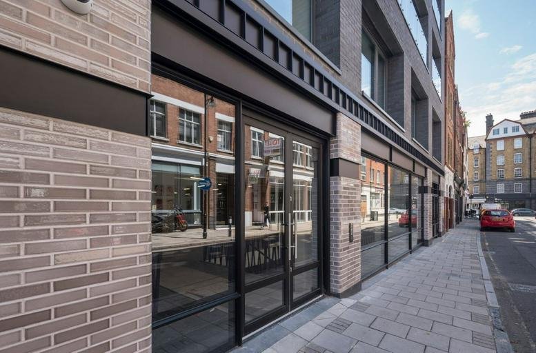 Ground floor exterior of 30A Great Sutton Street featuring brickwork and large glass entrance doors.