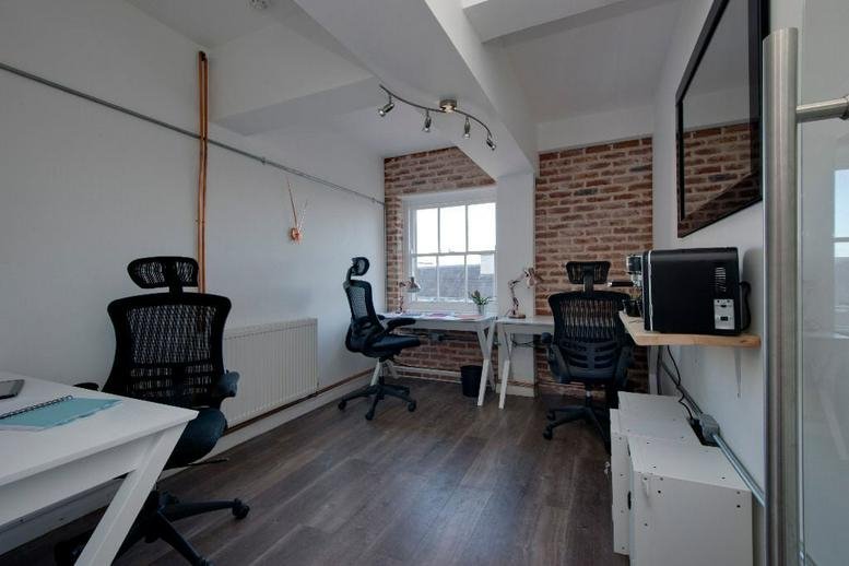 Bright, modern open-plan workspace at 31 Berkeley Square, Bristol featuring brick accents and ergonomic chairs.