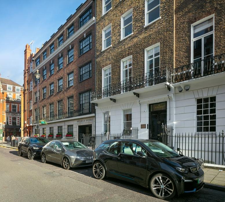 Exterior view of the historic brick and stone facade at 32 Welbeck Street, Marylebone, London.