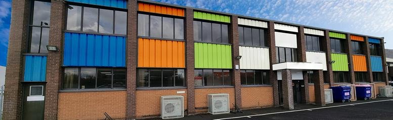 Exterior facade of Spelthorne Business Hub featuring colorful blue, orange, and lime green panels.