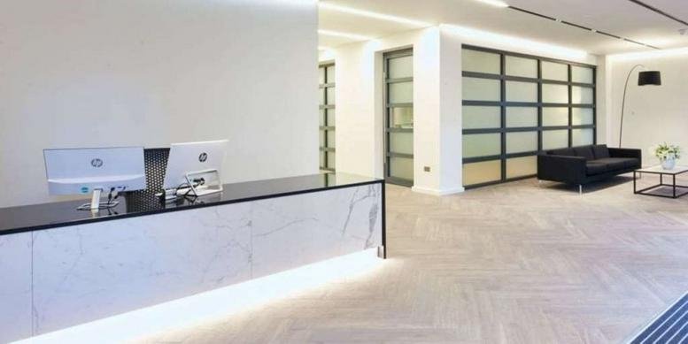 Reception area with marble front desk and lounge seating at 33 Soho Square, 2nd Floor, Central London.