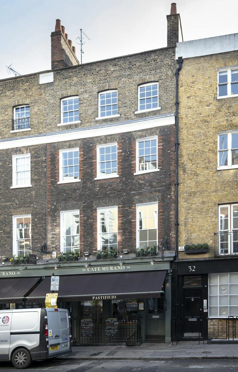 Exterior brick facade of 34 Tavistock Street featuring Cafe Murano on the ground floor.