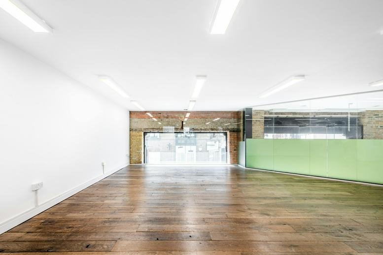 Spacious open-plan office at 35 Artillery Lane featuring rustic wooden floors and bright recessed lighting.