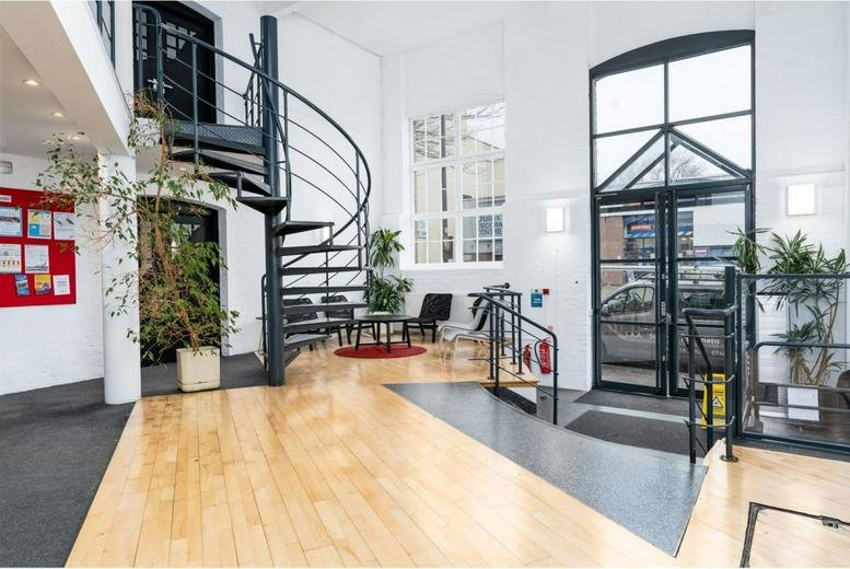 Spacious reception at 39, 41 North Road with a spiral staircase, light wood flooring, and large windows.