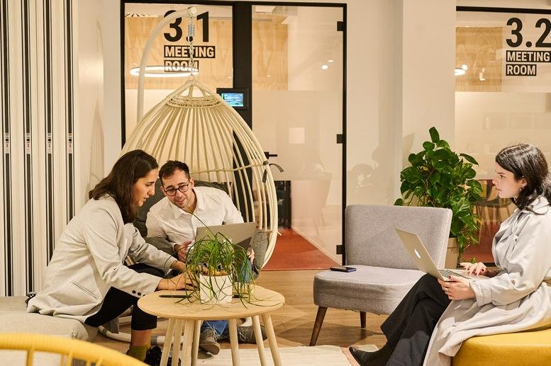 Exterior view of office building with modern facade and surrounding trees.