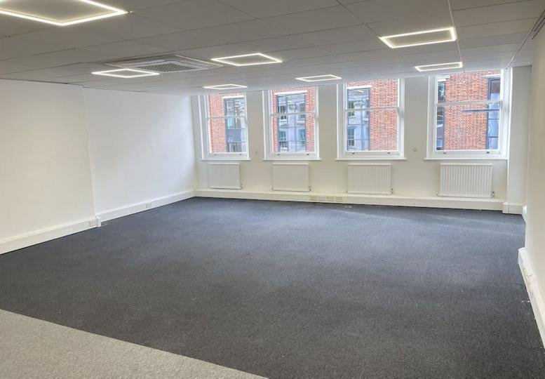 Spacious open-plan office area at 39, Hatton Garden, London with grey carpeting and bright LED ceiling panels.