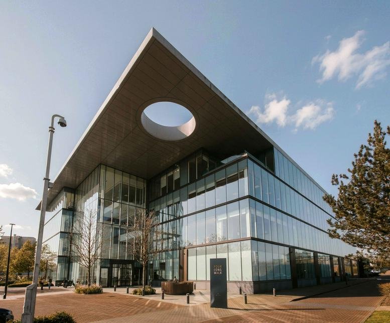 Exterior view of the modern glass-facade building at 4 Longwalk, Stockley Park, Hayes.