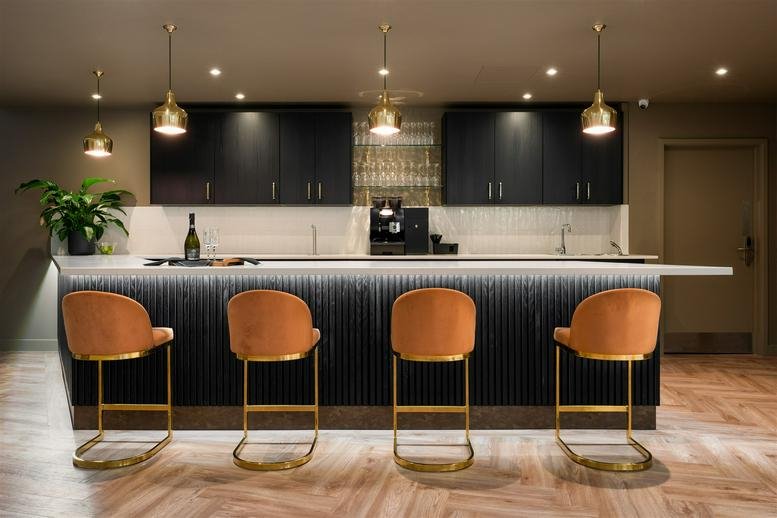 Sleek modern bar area at 4, Torwood Street, Torquay with velvet stools and warm pendant lighting.