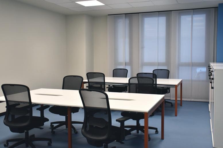Meeting room at 4, Via Galileo Ferraris, Napoli featuring white tables and black mesh chairs.