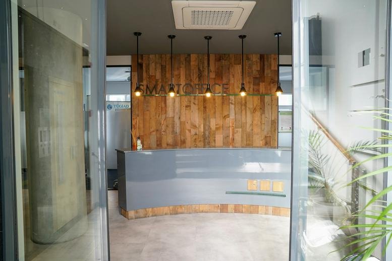 Sleek modern reception desk at Smartoffice with warm wood paneling and pendant lights.