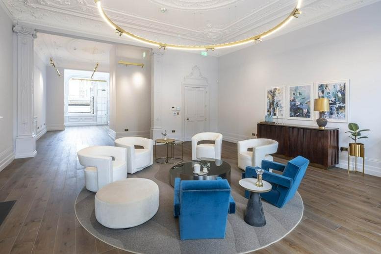 Communal lounge with blue and white armchairs and a circular overhead light.