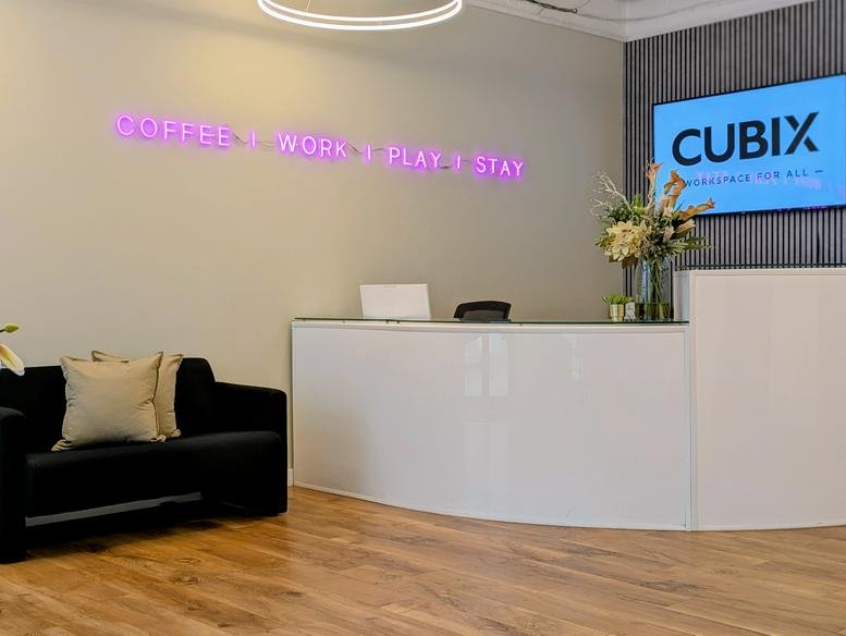 Modern reception area of 6th Floor, 42, 50 Kimpton Road with a curved white desk and neon wall sign.