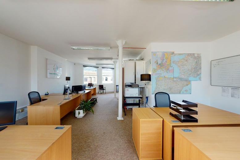 Spacious open-plan office at 43-45, Saint John Street, London with wooden desks and natural light.