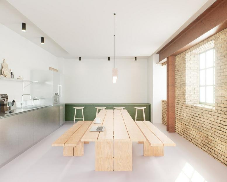 Spacious communal dining area at 44-46 New Inn Yard with a large wooden table and exposed brick wall.
