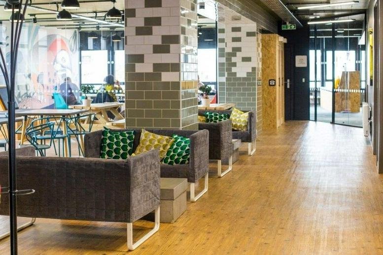 Colorful breakout area at 44 Bond Street with plush sofas and patterned pillars.
