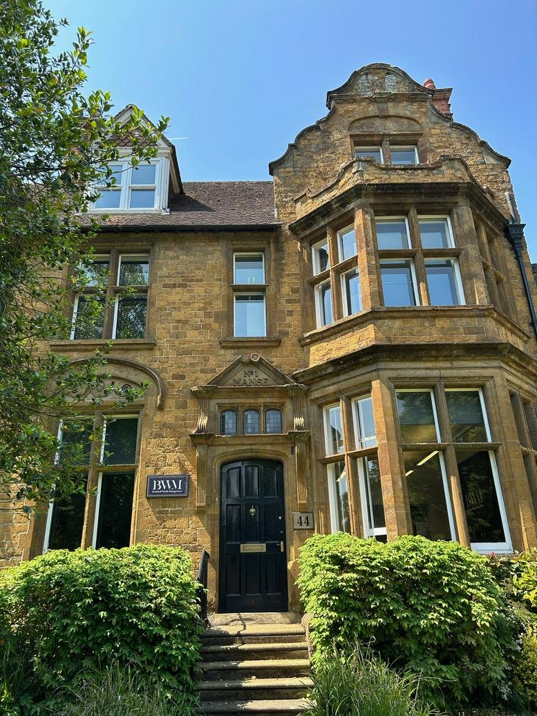 Grand stone exterior facade of 44, South Bar Street, Banbury, Oxfordshire with a black front door.