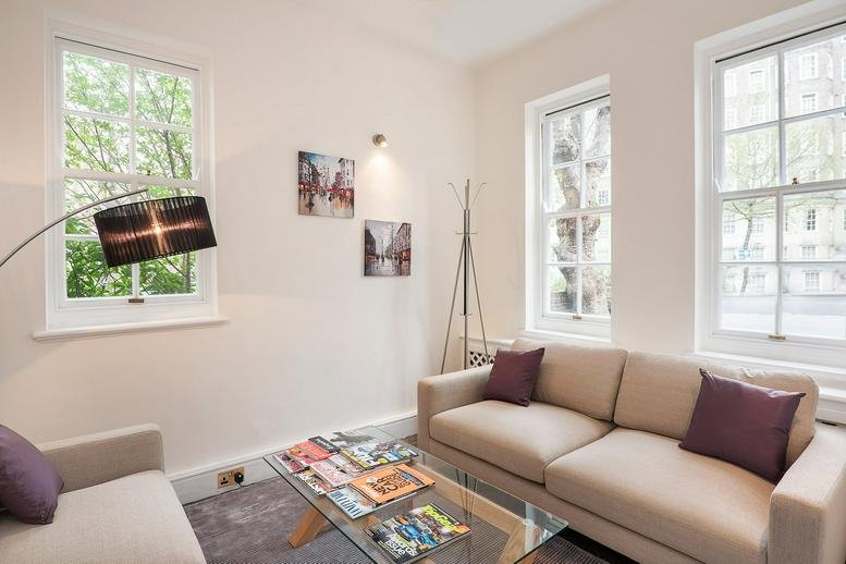 Bright breakout lounge at 45 Circus Road with cream sofas and a glass coffee table.