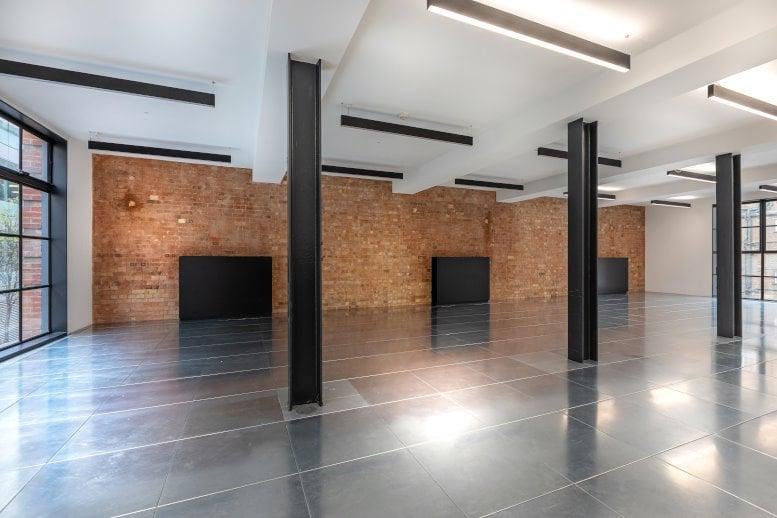 Spacious open-plan industrial space at 45 Eagle Street, Eagle Courtyard, Camden with brick walls and steel pillars.