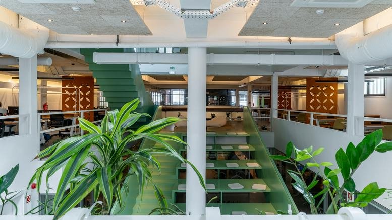 Spacious open-plan mezzanine at 45, Rua do Centro Cultural, Lisbon with lush green plants and modern lighting.