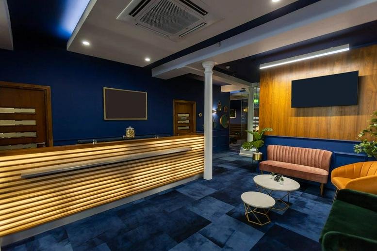 Spacious reception area at 49 Piccadilly House with a slatted wood desk and stylish lounge seating.