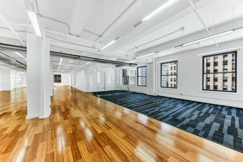 Spacious open-plan office at 49 Southwark Bridge Road with polished wood floors and large windows.