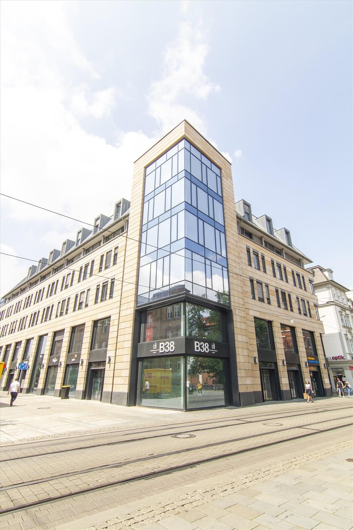 Modern exterior of the glass-facade Bahnhofstr. 38 building with retail ground floor.