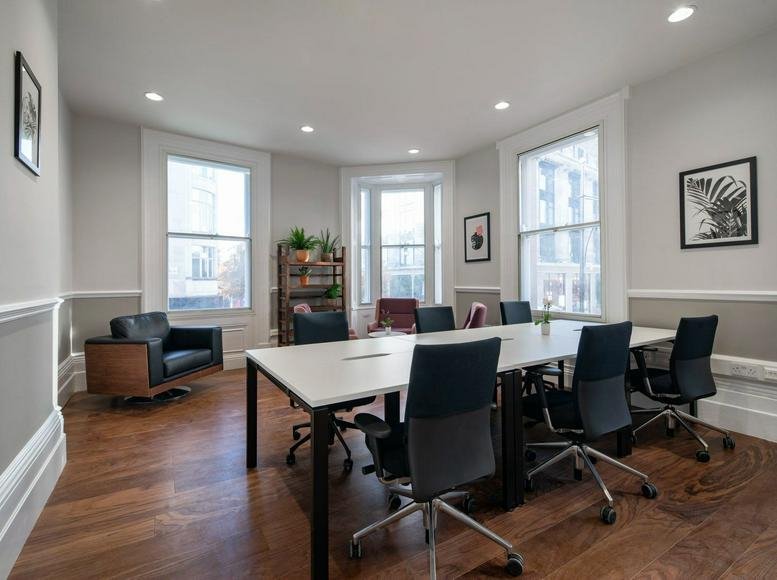 Spacious boardroom at 53 Duke Street, Central London, UK featuring a large white table and dark executive chairs.