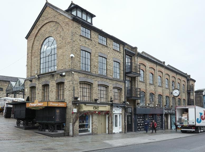 Exterior view of the brick facade at 54-56 Camden Lock Place featuring large arched windows.
