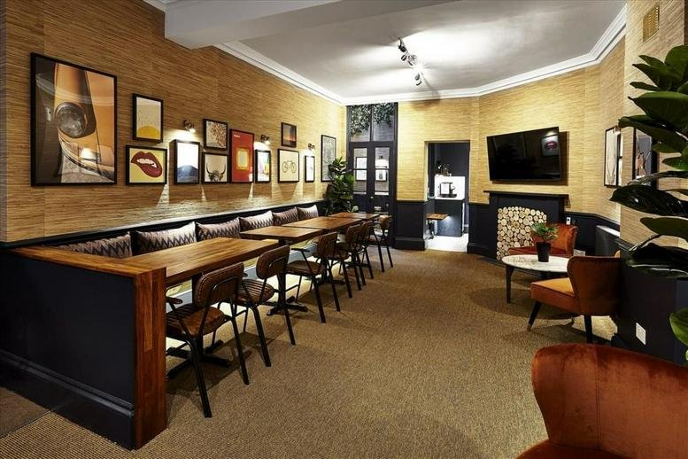 Spacious communal lounge at 54 Poland Street with wood paneling, gallery wall, and banquette seating.