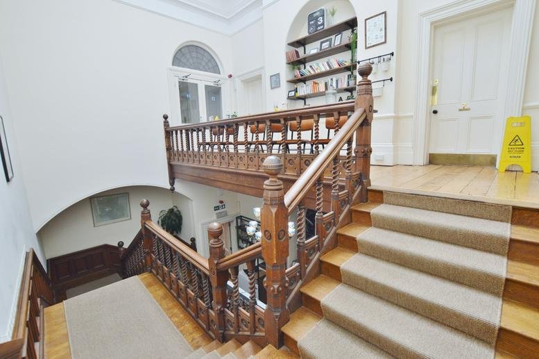Grand staircase at 56-58, Richmond Hill, Bournemouth with period features and wooden railings.