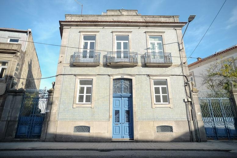 Front view of the traditional stone building facade with a central blue door.