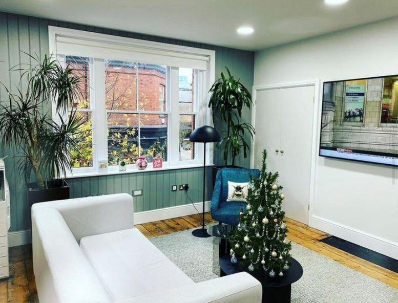 Lounge area at 6 Garden Place featuring a white sofa, Christmas tree, and large window.