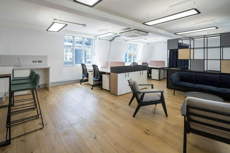 Spacious interior workspace at 6 Lloyd’s Avenue, London with modern lounge seating and warm wood flooring.