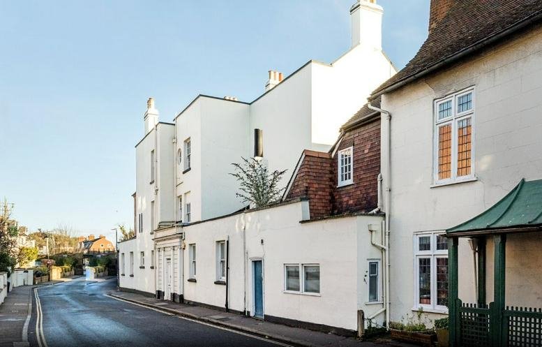 Street view of the building with white facade and traditional architecture