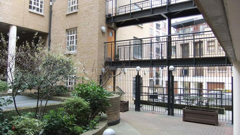 Exterior brick courtyard and gated entrance at Unit 2 Thorpes Yard, 61 Wapping Wall.