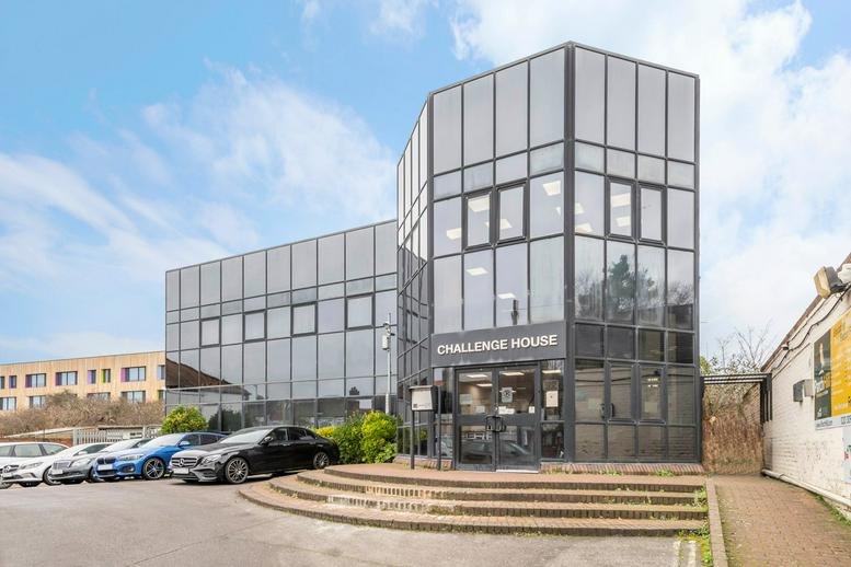 Exterior view of the multi-story glass facade and entrance at Challenge House.