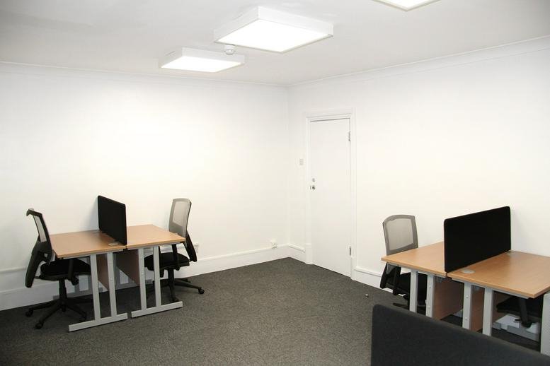 Spacious interior workspace at 61A West Ham Lane, Central London, UK featuring four desks and office chairs.
