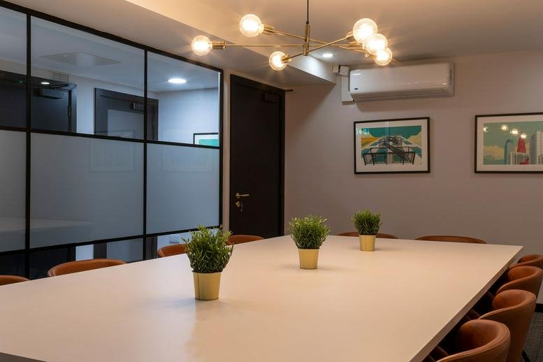 A professional boardroom at 65-66 Charlemont Street featuring a white table and modern light fixture.