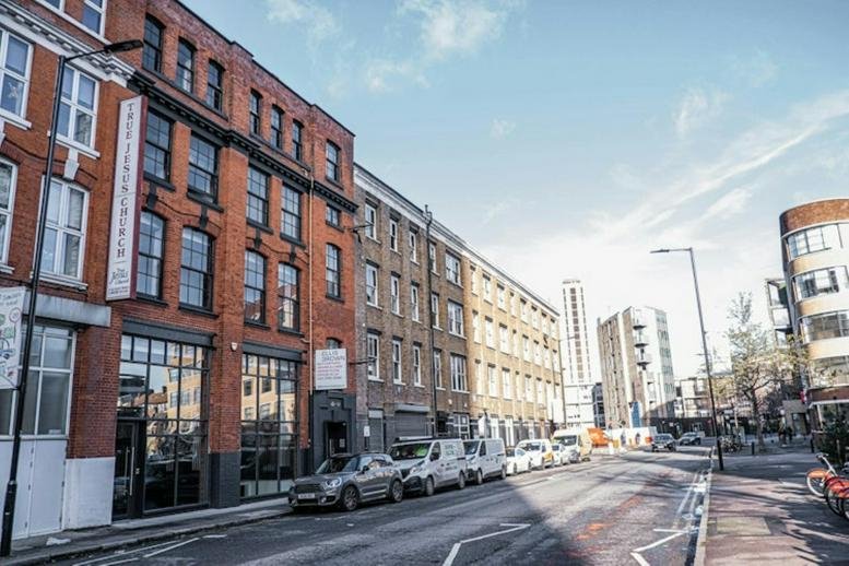 Exterior view of the red brick facade at 65-69 East Road showing large industrial windows.