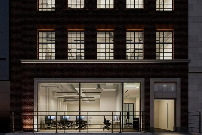 Evening exterior view of the brick facade and lighted ground floor at 66-67 Newman Street.