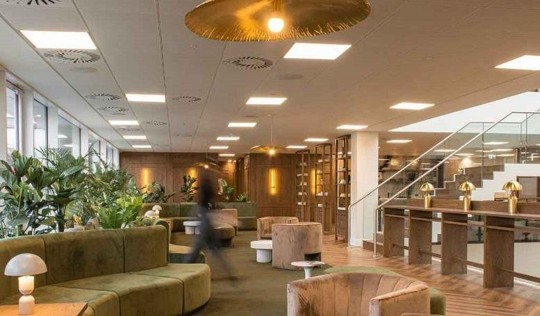 Spacious communal lounge at 68 King William Street with green velvet seating and designer lighting.